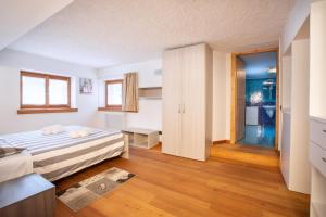 una camera con letto e porta per un bagno di Dolomites Seasons ad Alleghe