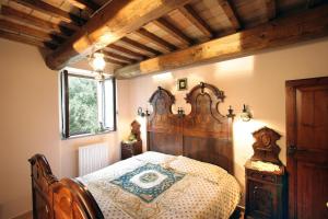 a bedroom with a bed with a wooden head board at Casa Vacanze La Meridiana in Serrungarina