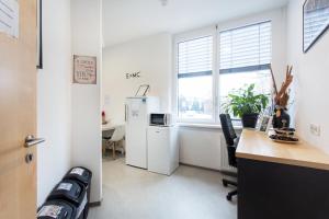 an office with a refrigerator and a desk and a window at MS Sparrow Hostel in Ljubljana