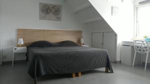 una camera con un letto e una coperta nera di Friendly Beach House a Baie Nettle