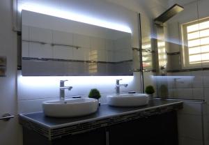 un bagno con due lavandini e un grande specchio di Friendly Beach House a Baie Nettle