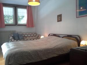 1 dormitorio con cama y sofá en Dolomiti Sella Ronda, en Campestrin