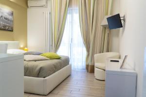ein Schlafzimmer mit einem Bett, einem Stuhl und einem Fenster in der Unterkunft Al Parco Verde B&B in Sorrent