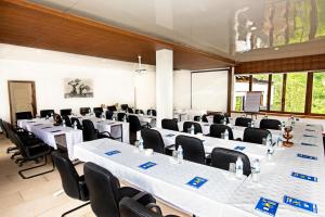 uma sala de conferências com mesas e cadeiras brancas em Safari Beach Lodge em Senga