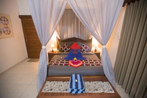 a bedroom with a bed with a blue bedspread at Jirna House in Ubud +21 photos