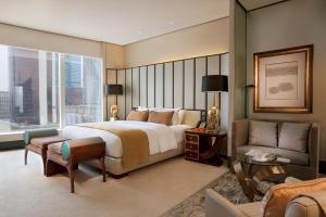 een hotelkamer met een groot bed en een bank bij MGM Macau in Macau