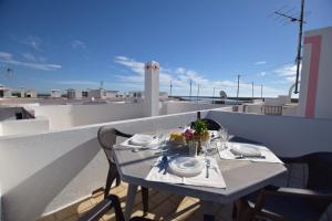 une table avec une assiette de nourriture sur un balcon dans l'établissement Carob By Algartur, à Santa Luzia