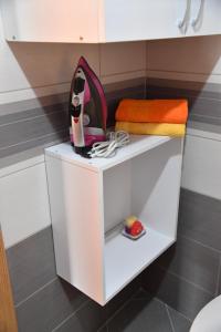 a white shelf in a bathroom with a towel at Apartment with free parking Marija in Niš