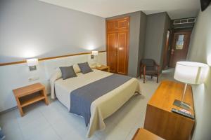 a hotel room with a large bed and a table at Hotel Teruel in Vinaròs