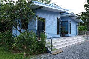 ein blaues Haus mit einer Treppe, die zur Eingangstür führt in der Unterkunft Binlar Home บินหลา โฮม in Nakhon Nayok