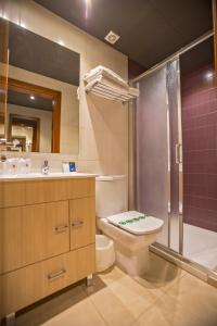 Un baño con inodoro, lavabo y ducha. en Hotel Teruel, en Vinarós