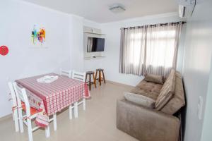 una sala de estar con una mesa y un sofá en CAMILA, en Bombinhas