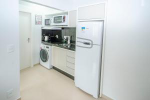 una cocina con refrigerador y lavadora y secadora en CAMILA, en Bombinhas