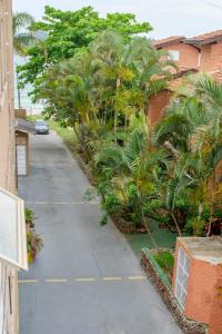 Una calle vacía con palmeras y un edificio. en CAMILA, en Bombinhas
