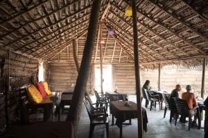 a group of people sitting at tables in a restaurant at Agonda Paradise in Agonda
