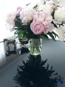 a vase filled with pink and white flowers on a table at Villa Cheval in Auk&scaron;tadvaris
