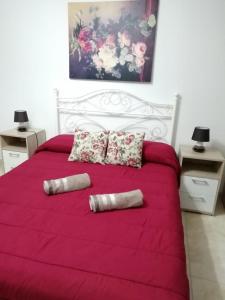 1 dormitorio con cama blanca con sábanas y almohadas rojas en Citadel View Studio Penthouse en Kerċem