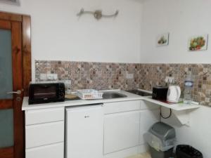 cocina con fregadero y microondas en Citadel View Studio Penthouse en Kerċem