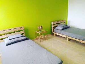 - 2 lits dans une chambre dotée d'un mur vert dans l'établissement Tarrafal's Meeting Point, à Tarrafal