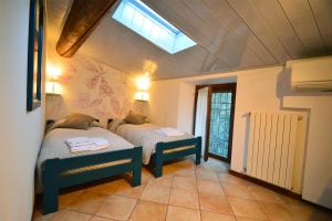 a bedroom with two beds and a skylight at Agriturismo La Filanda in Manerba del Garda