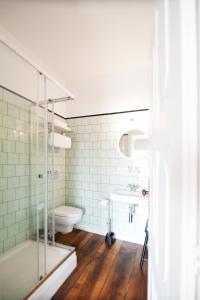 a bathroom with a shower and a toilet and a sink at Apartamentos com História in Guimarães