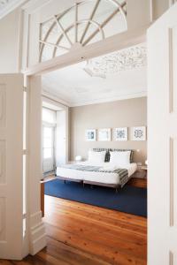 a bedroom with a bed and a blue rug at Apartamentos com História in Guimarães