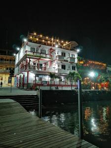 un gran edificio blanco con luces encendidas por la noche en Hotel La Union, en Flores