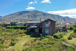a house with a mountain in the background at The Amaryllis Luxury Apartment Bella Donna in Bettyʼs Bay