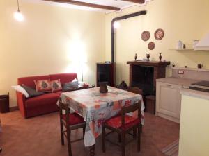 uma sala de estar com uma mesa e um sofá vermelho em Relax nel tufo em Pitigliano