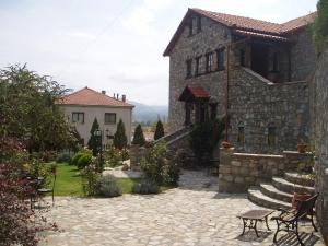 a stone house with a patio and a building at Guesthouse Agonari in Sklíthron