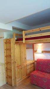 - une chambre avec des lits superposés et un canapé rouge dans l'établissement Coeur des Alpes, à Combloux