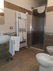 uma casa de banho com um chuveiro, um WC e um lavatório. em Relax nel tufo em Pitigliano