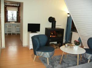een woonkamer met een stoel en een fornuis bij Apartamenty Domek Myśliwski in Karpacz