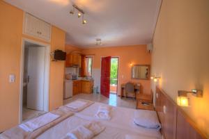 a bedroom with a large bed and a kitchen at Calderimi Lefkada in Nydri