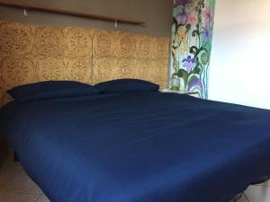 レーヴィコ・テルメにあるCasa FLO zero22104-AT-zero55251のベッド(青い掛け布団、ヘッドボード付)