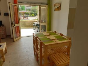 a dining room with a table and chairs and a door at Djasal Moradias in Santa Maria