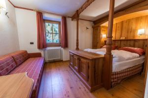 
a bedroom with a bed and a window at Rifugio Lago Nambino in Madonna di Campiglio

