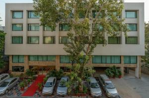 a building with cars parked in front of it at The President-A Boutique Hotel in Ahmedabad