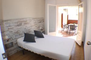 sypialnia z dużym białym łóżkiem z czarnymi poduszkami w obiekcie Agi Sant Jordi w mieście Roses