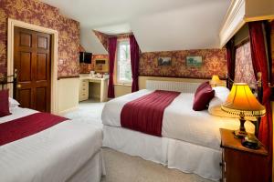 a bedroom with two beds and a lamp on a table at Brookfield B&B Guest House in Keswick