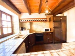 eine Küche mit einer Spüle und einer Mikrowelle in der Unterkunft C3 Bordes d'Arinsal, Rustico con Chimenea, Arinsal, Zona Vallnord in Arinsal