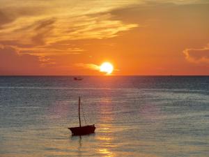 ein Boot im Ozean bei Sonnenuntergang in der Unterkunft Jabar Lodge in Zanzibar City