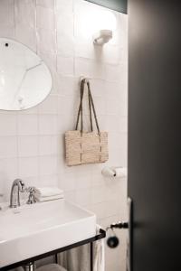 a white bathroom with a sink and a mirror at Maison Volver in Arles