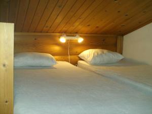 a bedroom with two beds with white pillows at Pankkotupa 8B in Punkaharju