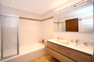 La salle de bains est pourvue d'une baignoire, d'un lavabo et d'une douche. dans l'établissement Appartement Lackner, à Zell am See