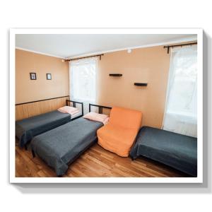 イリイチにあるGuest House Marinaのベッド3台とオレンジの椅子が備わる客室です。