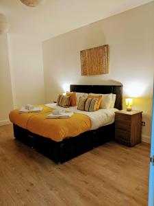 a bedroom with a large bed with orange sheets at Sapphire House Telford in Telford