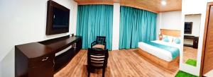 a bedroom with a bed and a desk and a television at Aranyavilas in Shimla