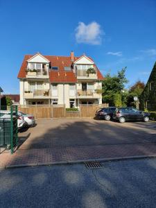 ein Parkplatz mit Autos vor einem Haus in der Unterkunft Haus am Grömitzer Deich in Grömitz