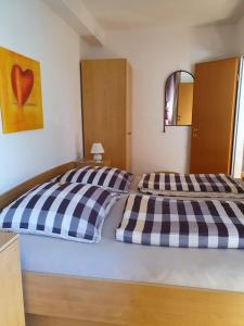 Schlafzimmer mit einem Bett mit blauer und weißer Bettwäsche in der Unterkunft Haus am Grömitzer Deich in Grömitz